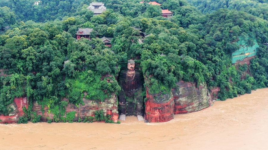 Estátua gigande de Buda teve os pés inundados de água e lama